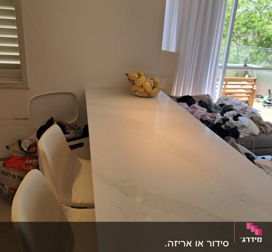 מטבח עם דלפק וכיסאות, סל כביסה ברקע